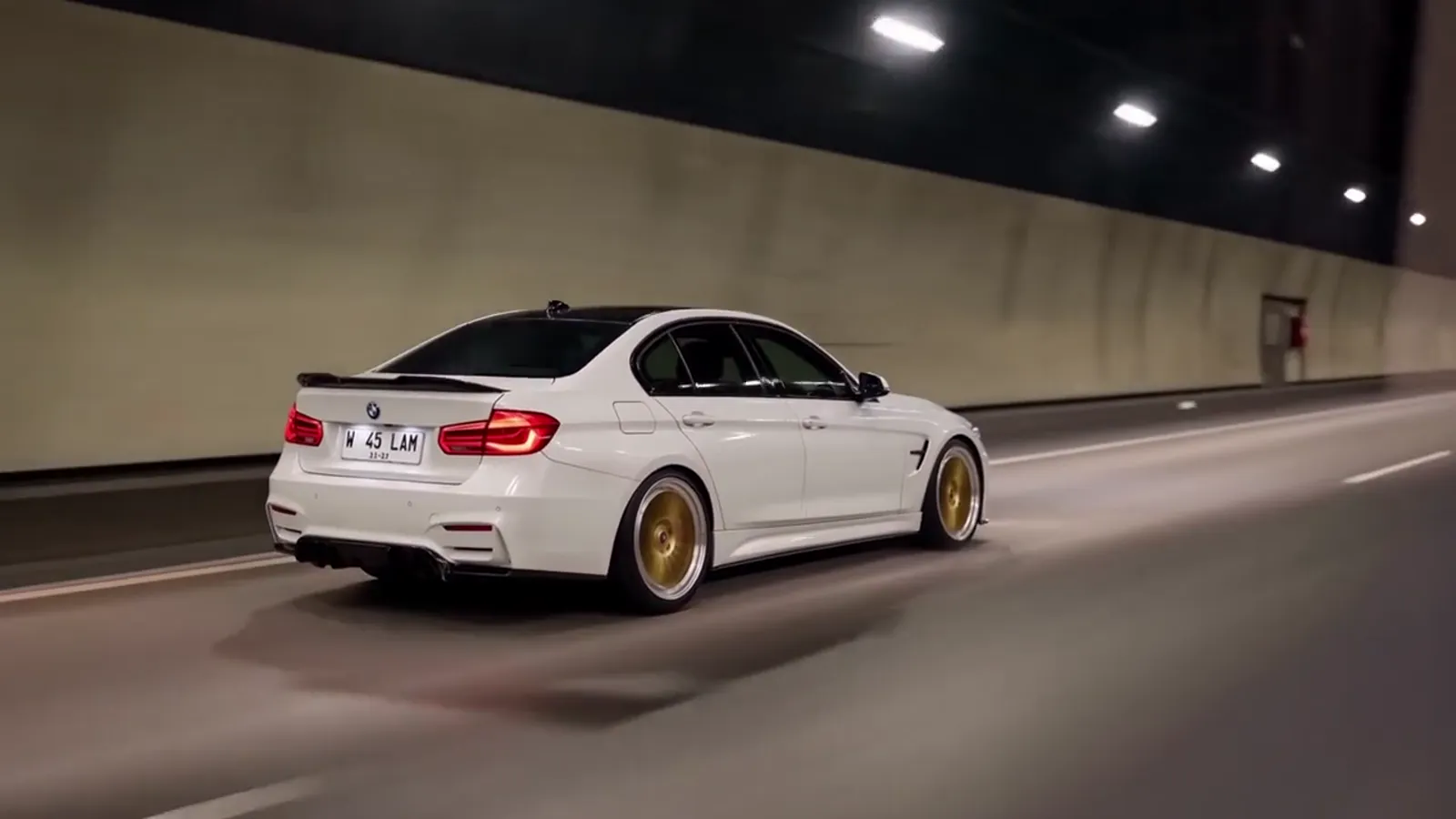 The same car, full size, driving through a lit tunnel